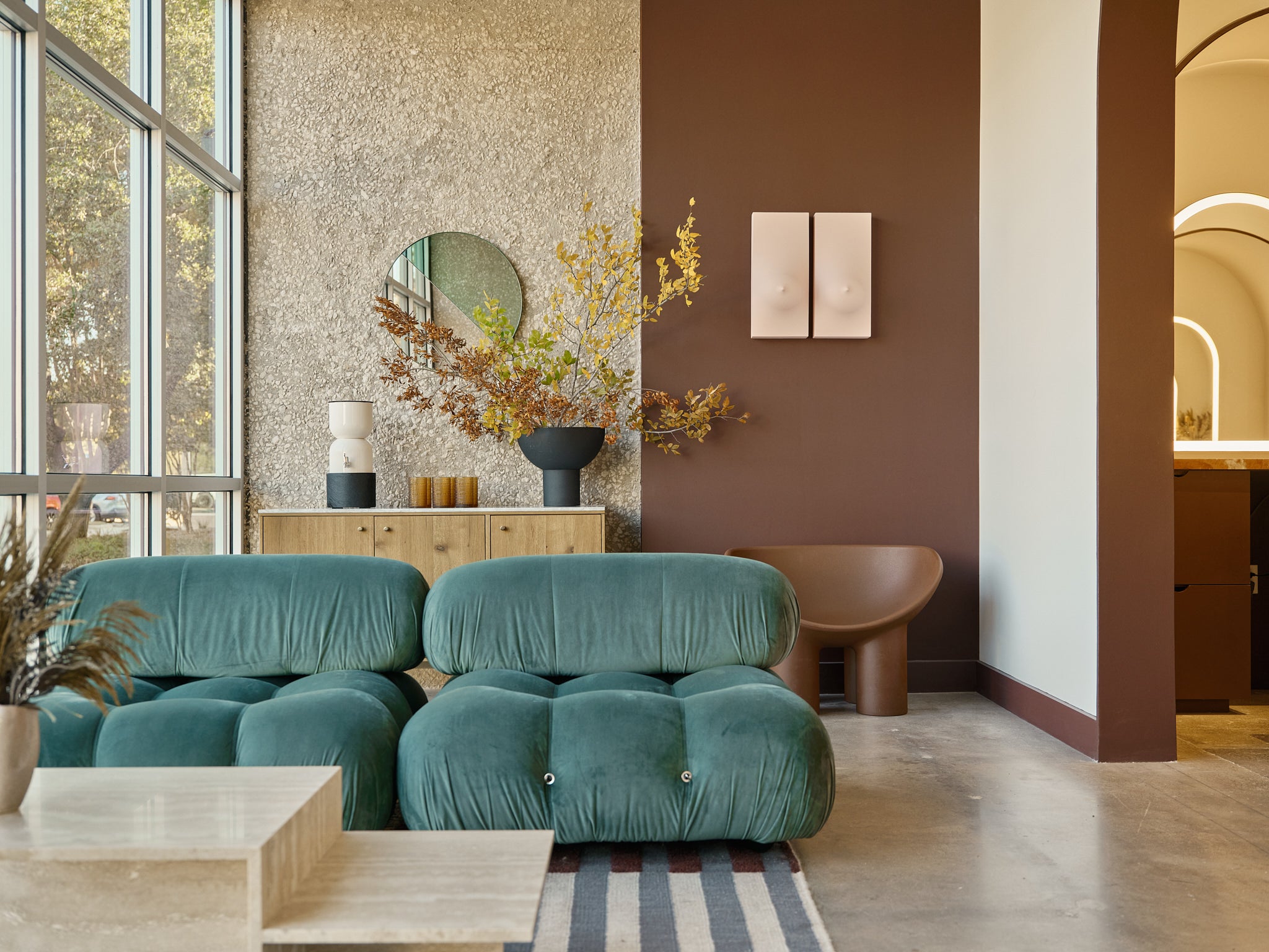 Inside Revel Workshop at the waiting area with green fluffy couches and breasts artwork on the wall
