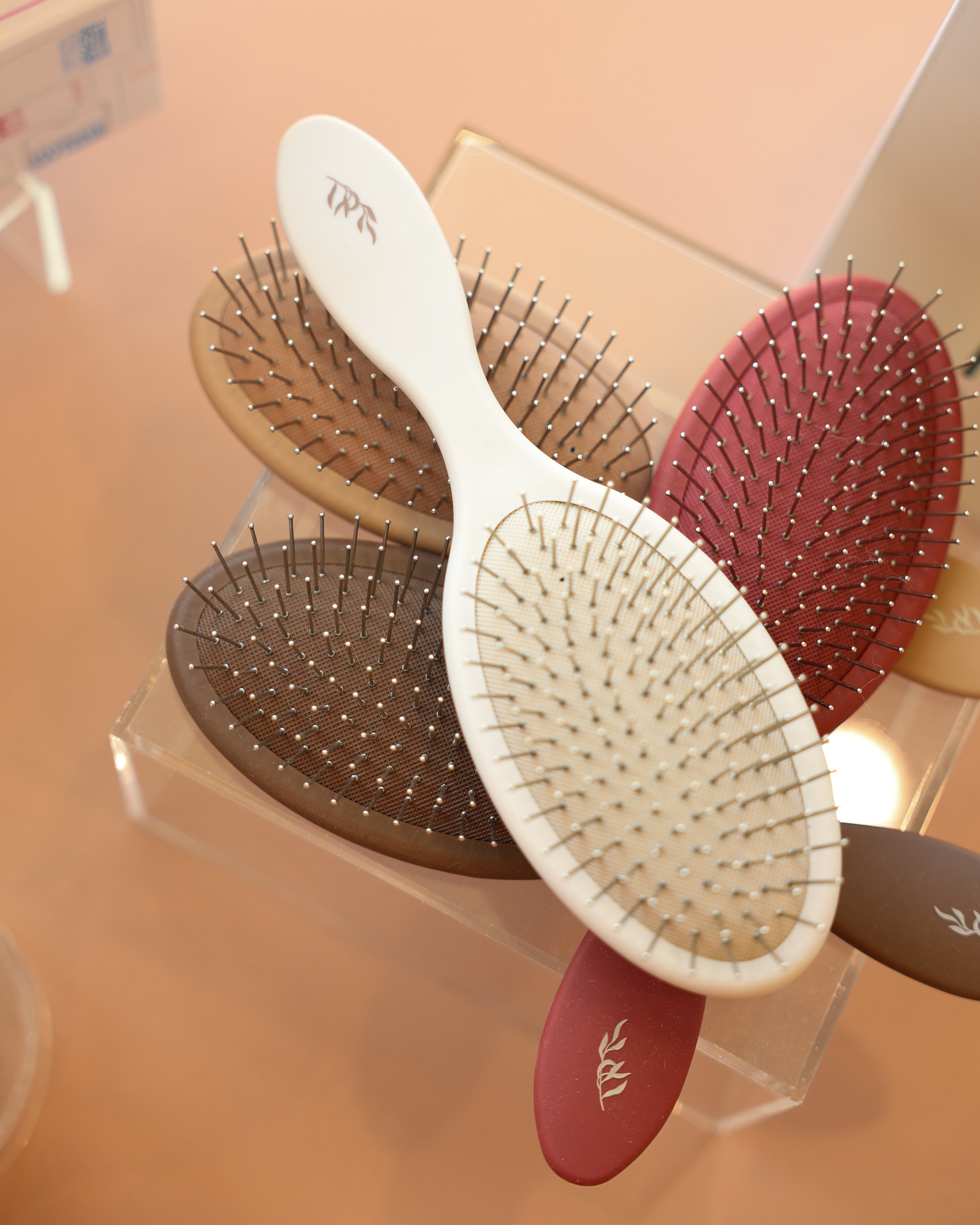 Set of Willow detangling hairbrushes with visible brand logo on a retail display stand.