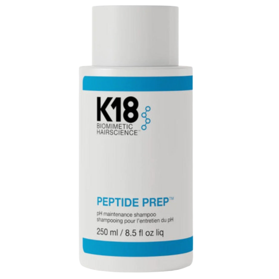 A bottle of K18 Biomimetic Hairscience Peptide Prep pH Maintenance Shampoo hair product with a white and blue label, indicating it is a hair care product with a volume of 250 ml.