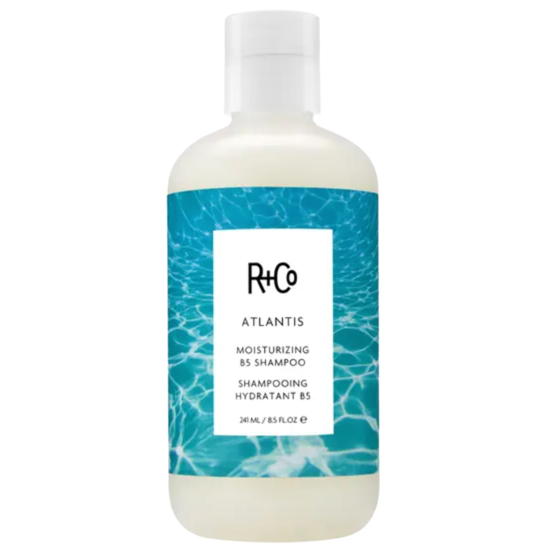 Bottle of R+Co ATLANTIS Moisturizing Shampoo with blue label design