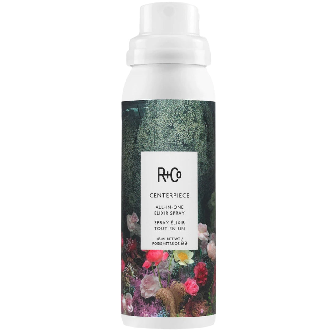 Travel size bottle of R+Co Centerpiece All-in-One Elixir Spray with floral design