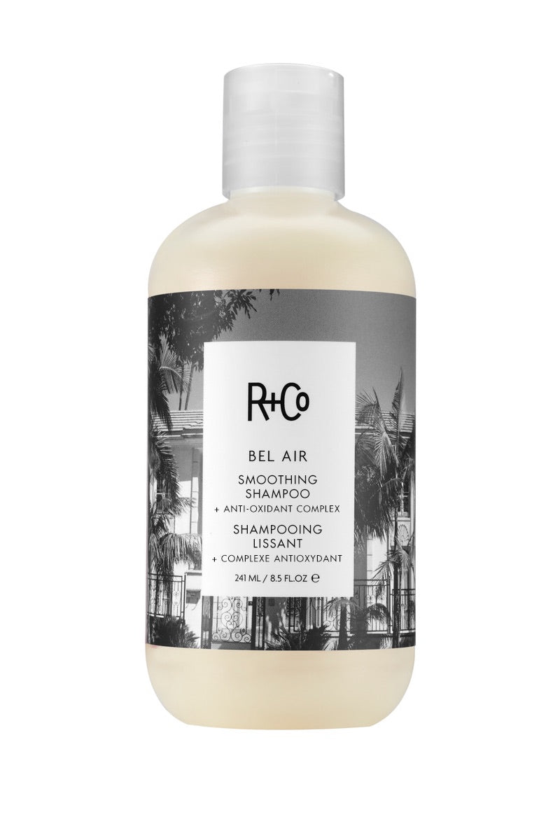 A bottle of Bel Air Smoothing Shampoo by R+Co with a white and black label design.