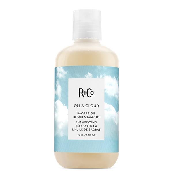 Bottle of On A Cloud Baobab oil Repair Shampoo by R+Co with a cloudy sky image on the label