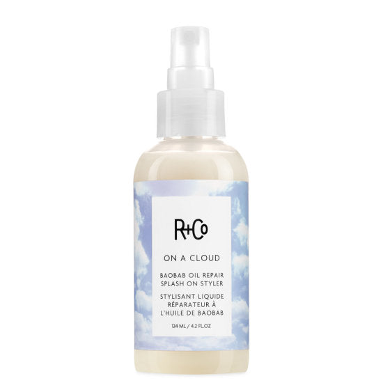 Bottle of R+Co On A Cloud Baobab Oil Repair Splash On Styler with cloud design on label