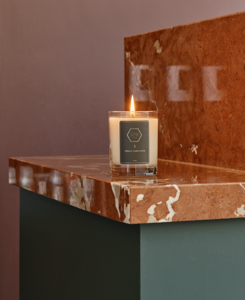 Revel Workshop candle in clear glass container with golden flame on top