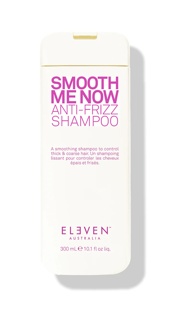 A bottle of ELEVEN Smooth Me Now Anti-Frizz Shampoo with white and pink labeling.
