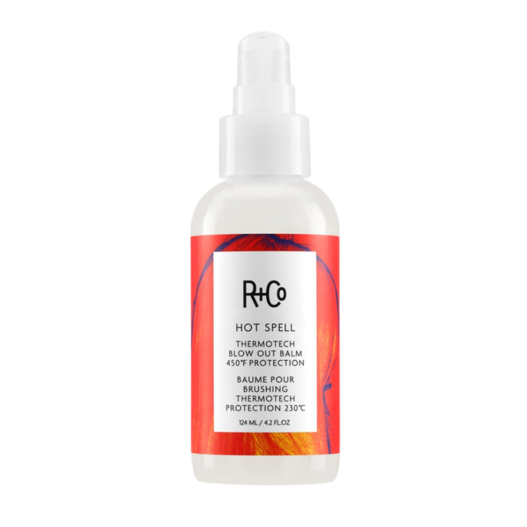 Bottle of Hot Spell Thermo Tech Blow Out Balm by R+Co, with a white pump dispenser and red label, on a white background.