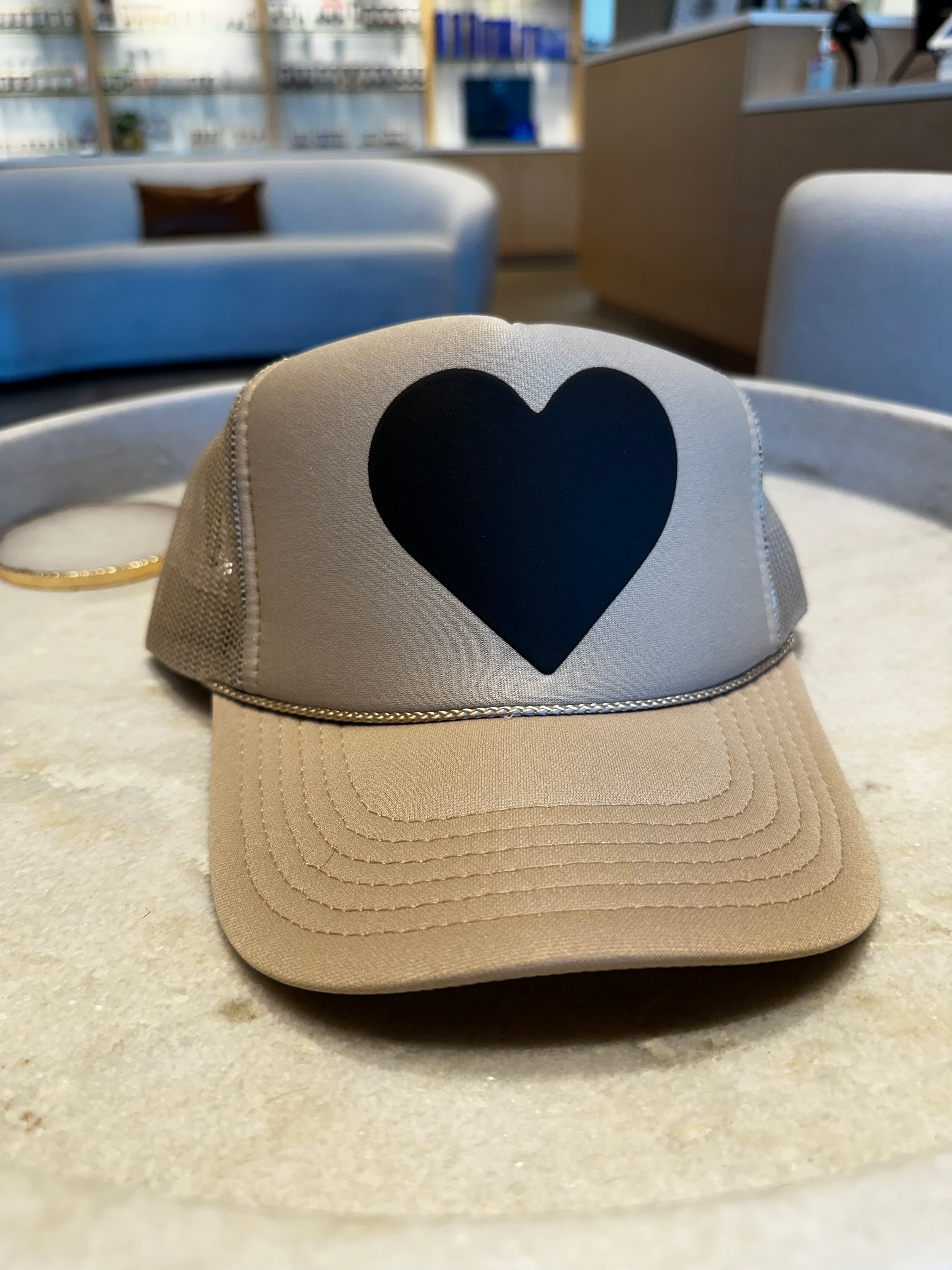 Beige trucker hat with large black heart logo