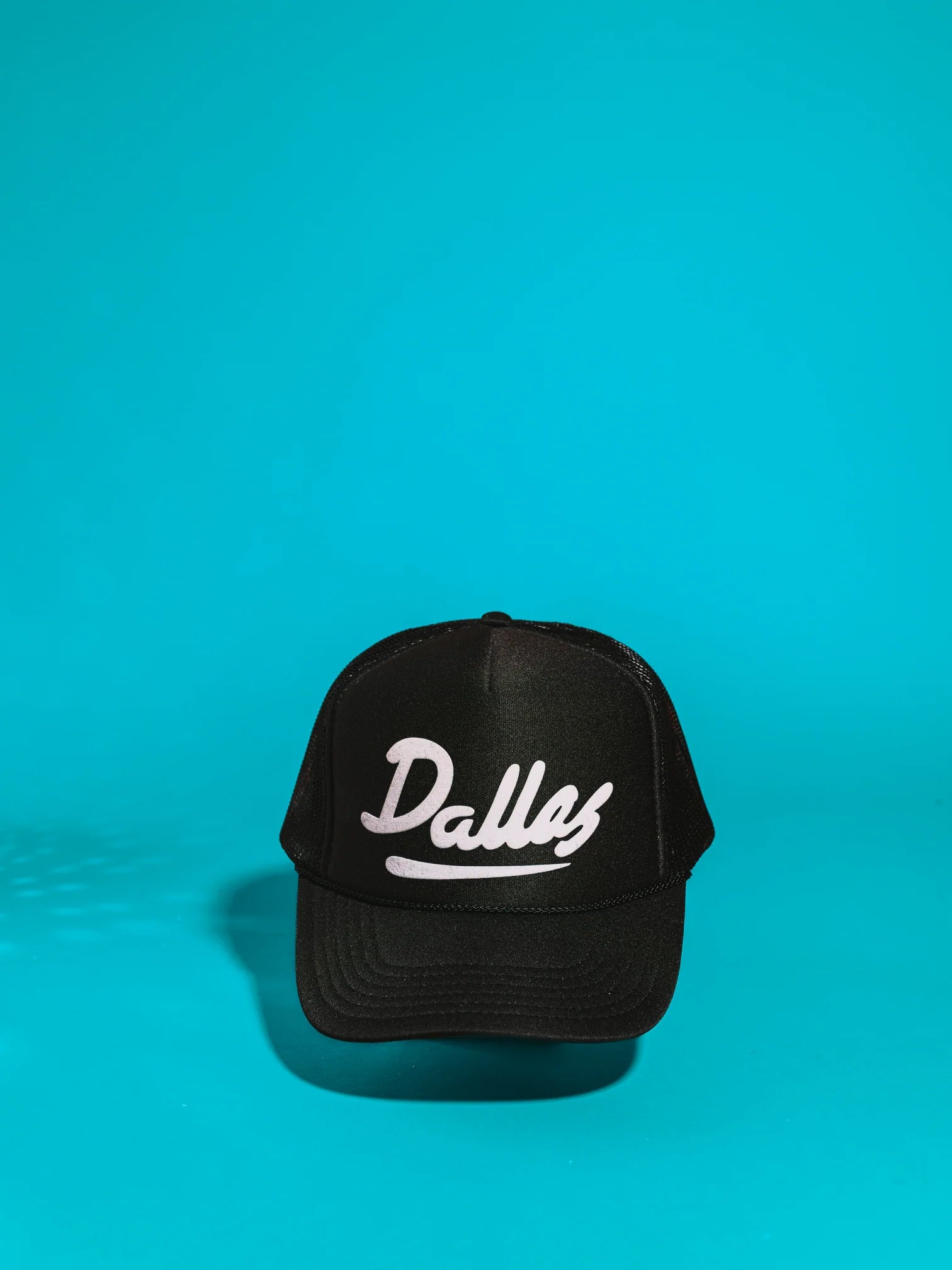 Black trucker hat with "Dallas" on the front in white letters