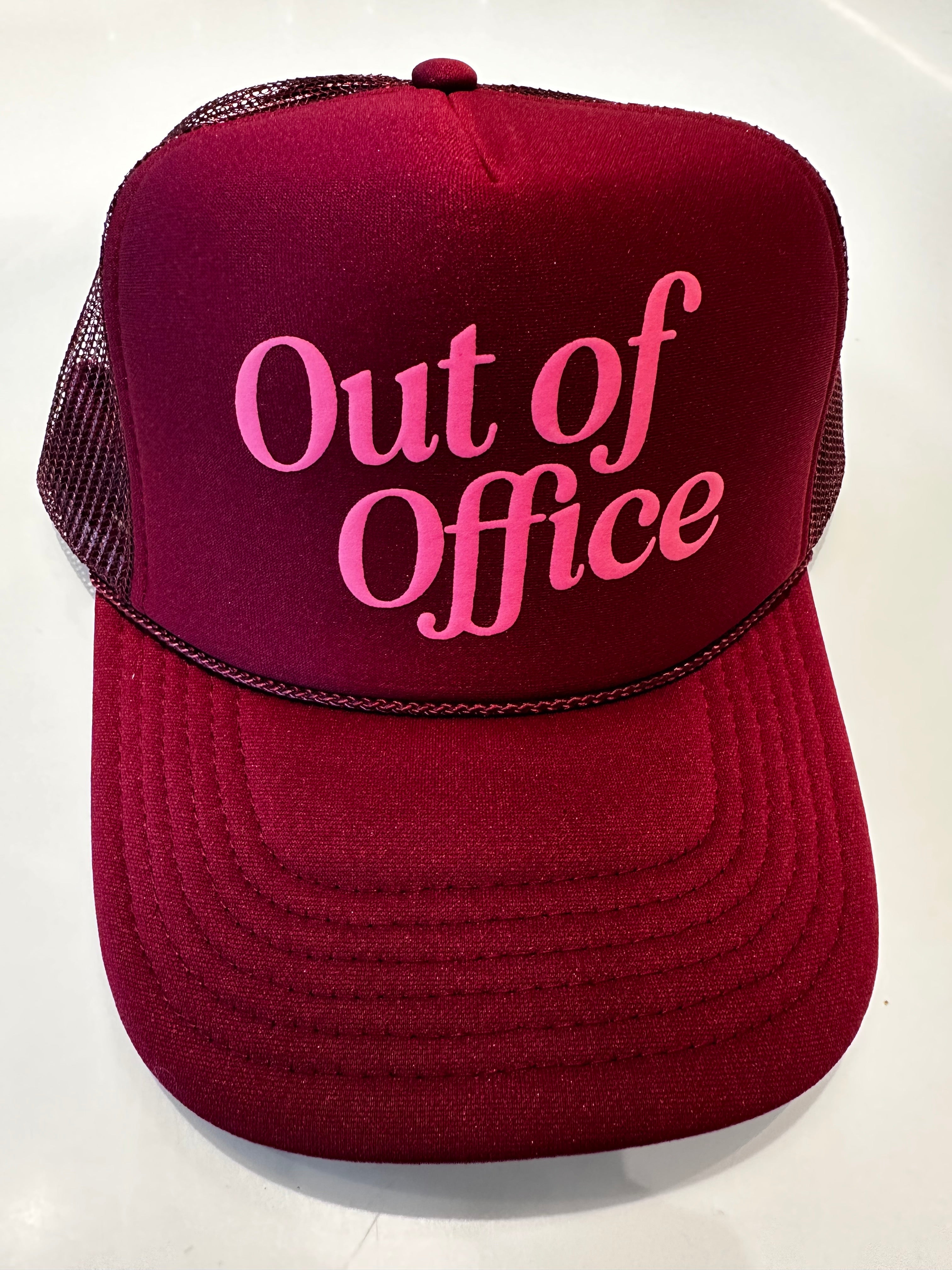Maroon trucker hat with 'Out of Office' text in pink on a white background