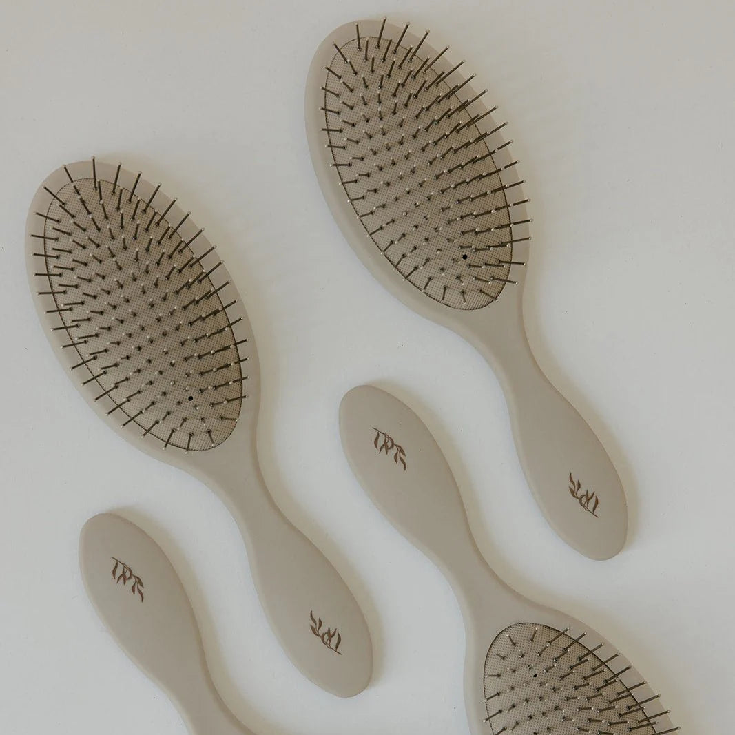 Set of five beige Willow detangling hairbrushes with dark bristles on a light background
