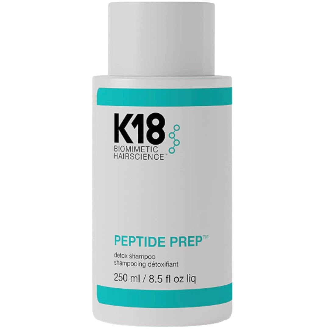 A bottle of K18 Biomimetic Hairscience Peptide Prep Detox Shampoo hair product with a white and blue label.