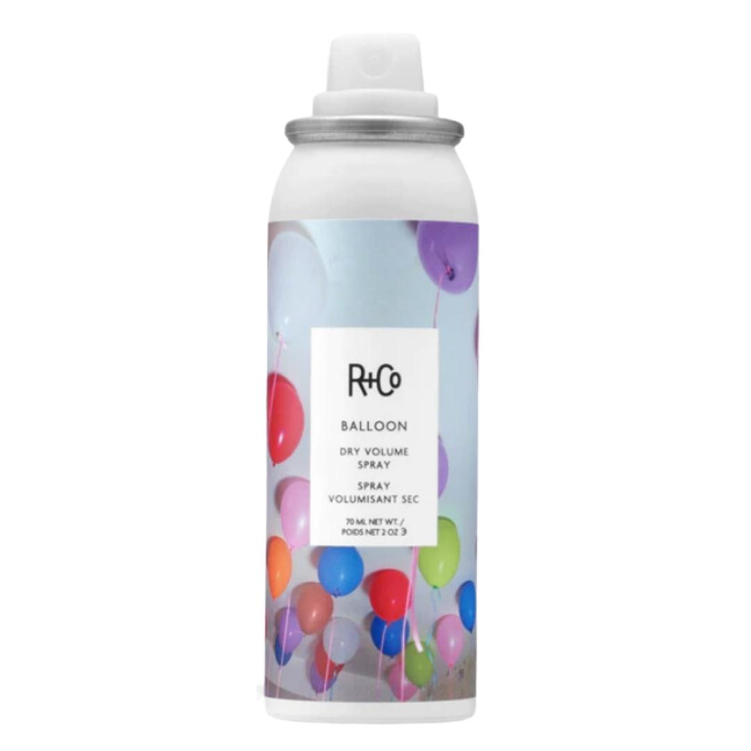 A can of R+Co Balloon Dry Volume Spray hair product with a multicolored balloon image on the label.