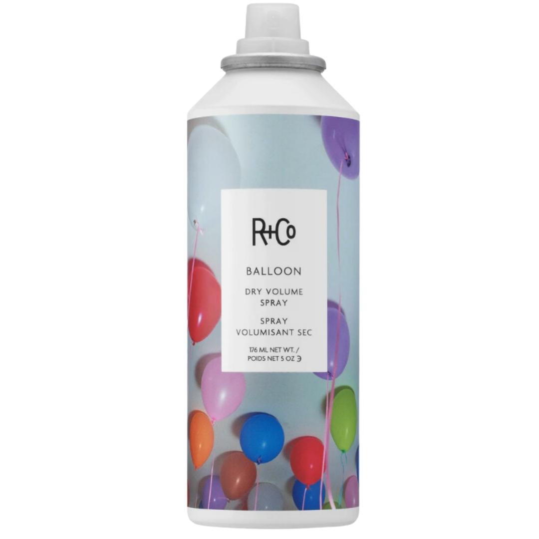 A can of R+Co Balloon Dry Volume Spray hair product with a multicolored balloon image on the label.