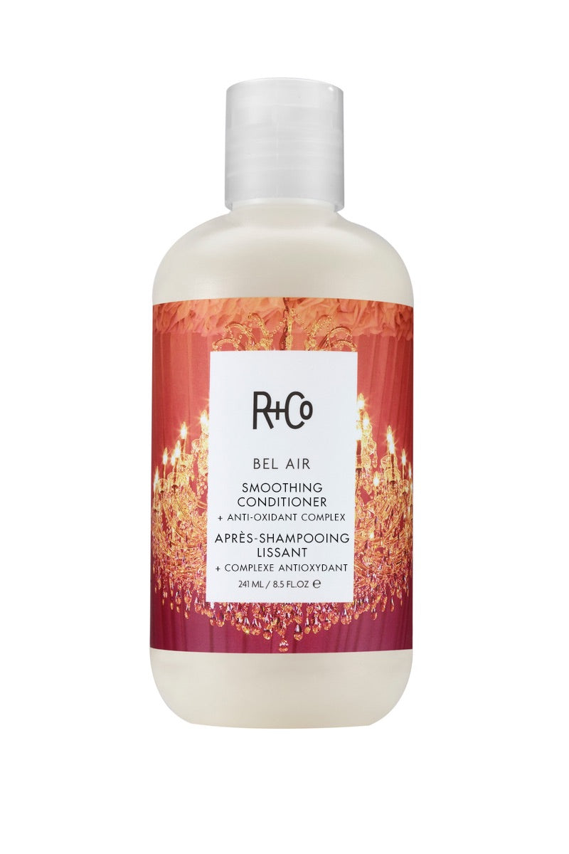 A bottle of Bel Air Smoothing Conditioner by R+Co, with a chandelier image on the label