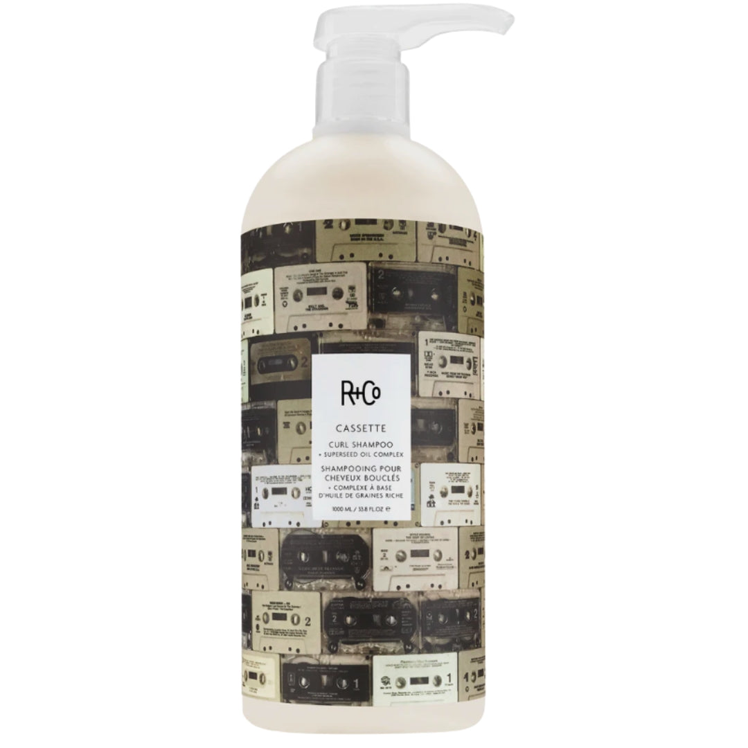 A bottle of Cassette Curl Shampoo by R+Co, with cassette tape images on the label