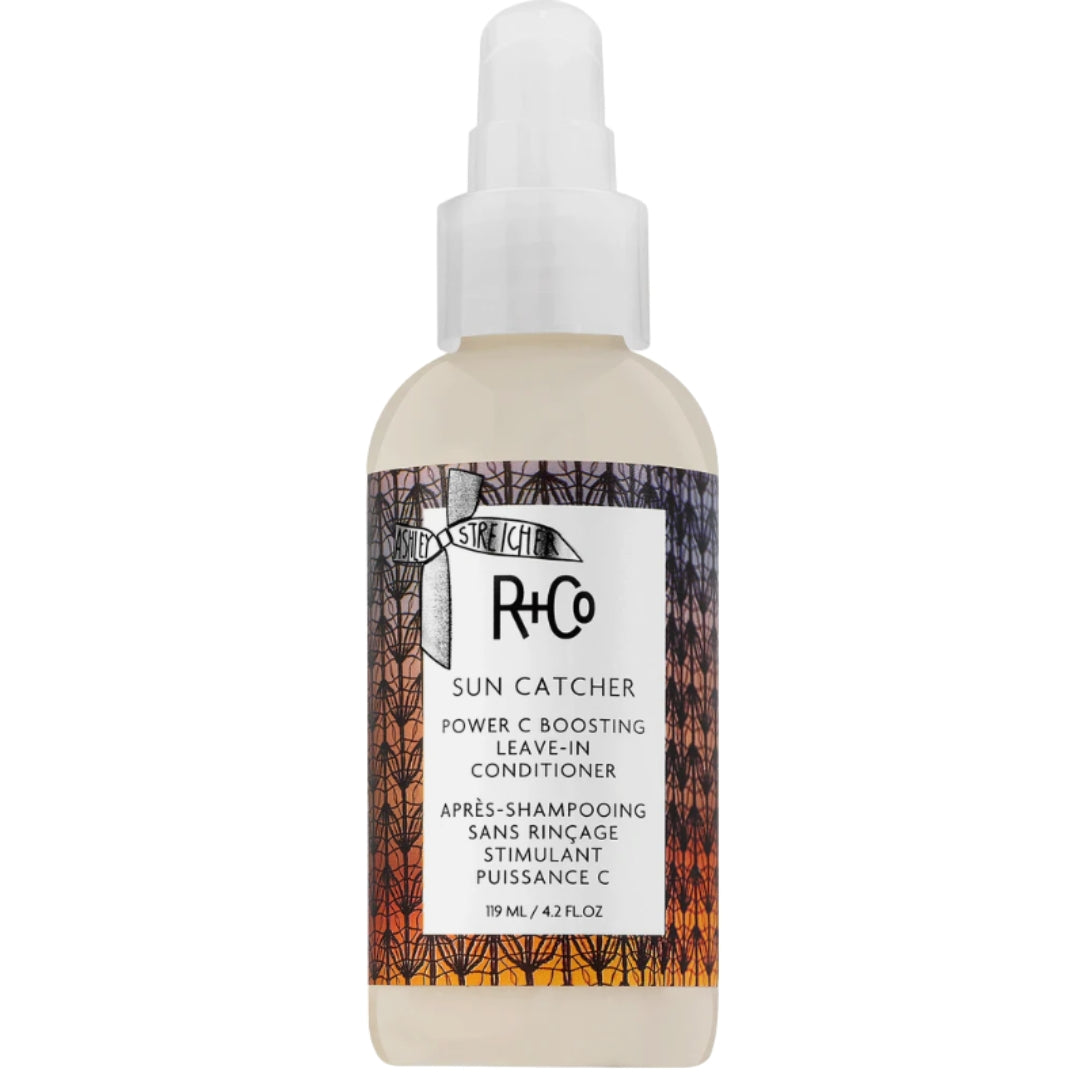 A bottle of R+Co Sun Catcher Power Fusion C Leave-in Conditioner with a spray pump