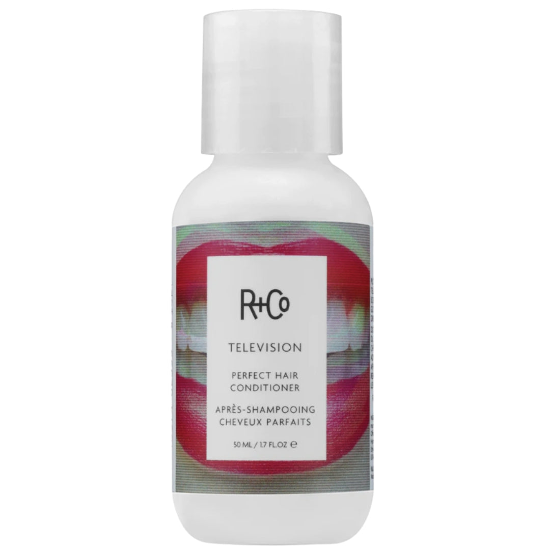 A travel-sized bottle of R+Co Television Perfect Hair Conditioner with a white background and image of smiling mouth with red lips