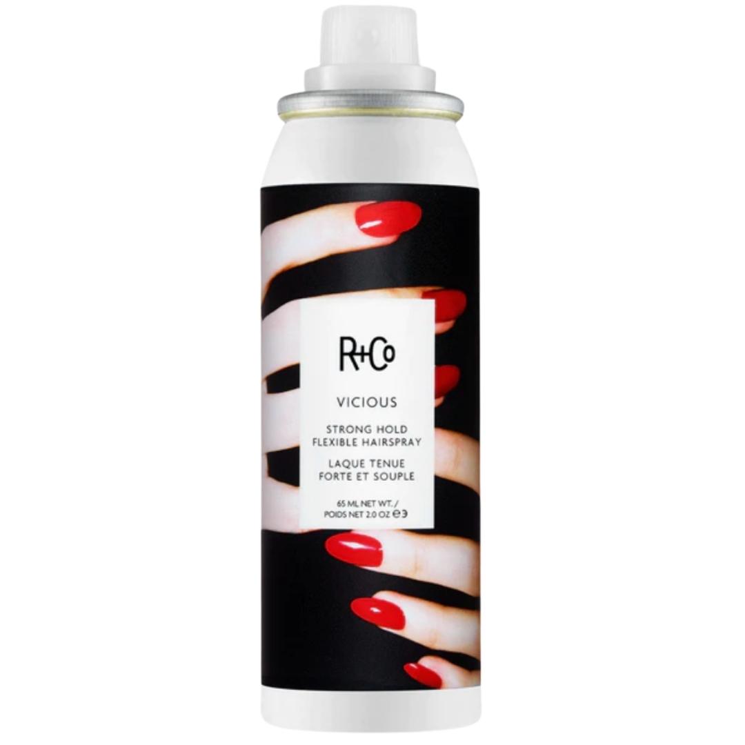 Black and white can of R+Co Vicious Strong Hold Flexible Hair Spray with image of hands with red fingernails on label