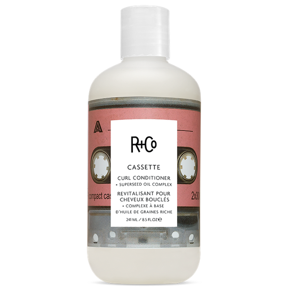 White bottle of R+Co Cassette Curl Conditioner with a cassette image on the label