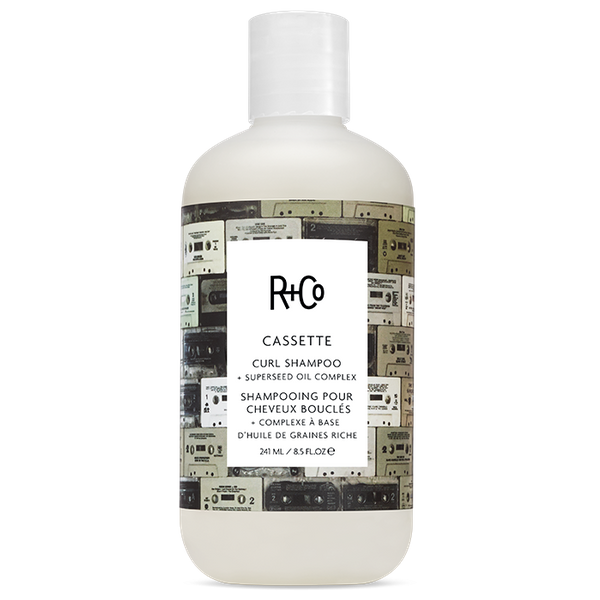White bottle of R+Co Cassette Curl Shampoo with cassettes image on the label