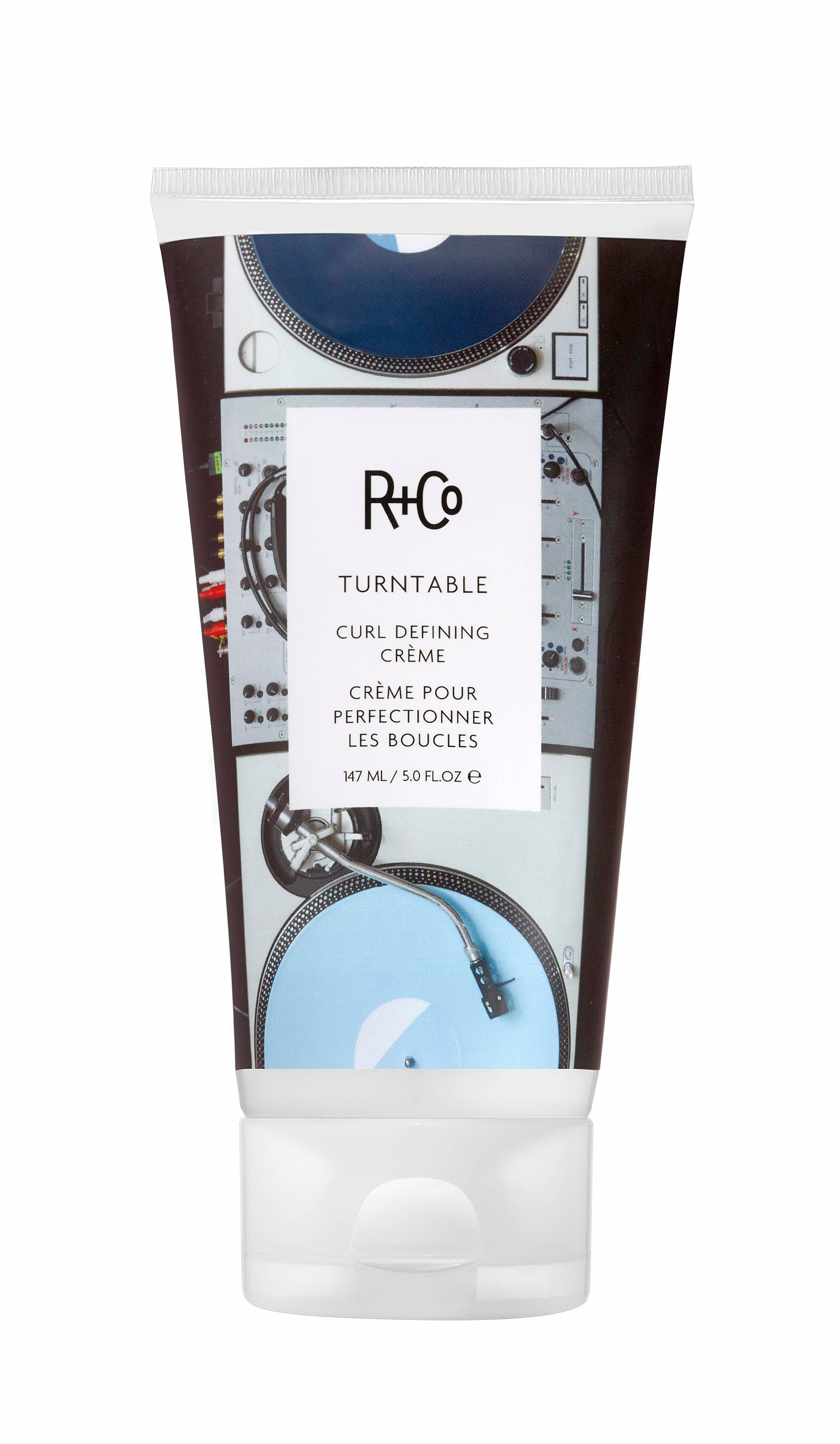 A tube of Turntable Curl Defining Crème by R+Co with a label featuring turntables and vinyl records.